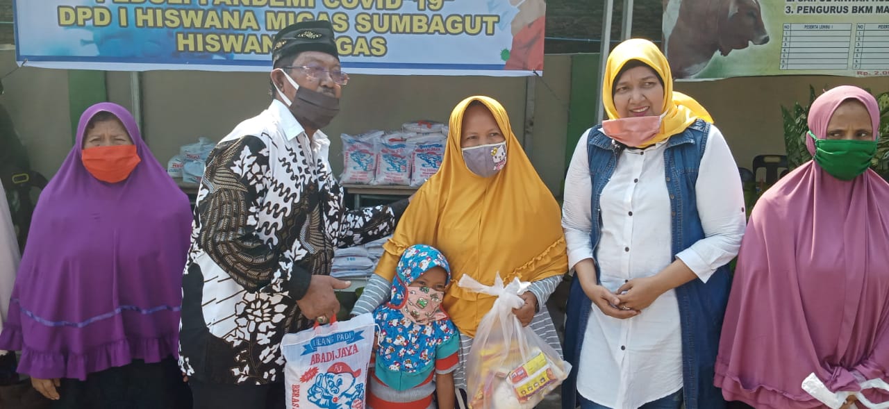 Ket. Foto : Kordinator wilayah (Korwil) Sumut, Majalah Berita Suara Perjuangan, suaraperjuangan.id dan infoindependen.com, Muktar.S didampingi istri Fina (jilbab kuning) membagikan ratusan paket sembako kepada warga dan wartawan di Halaman Masjid Al-Hidayah Dusun III Pasar VI Desa Manunggal.(ist)