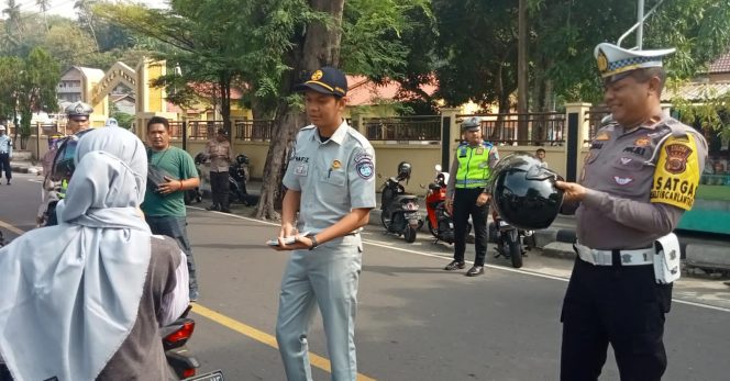 
					Foto: Kasat Lantas Polres Sabang, Ipda Rizal Bahnur bersama petugas Jasa Raharja, Afif membagi-bagikan brosur tentang pembayaran pajak kendaraan.
