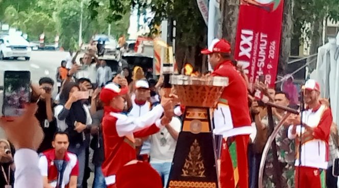 
					Foto: Pj Walikota Sabang menyerahkan Api PON kepada pelari pembawa Api PON di taman kota Sabang.