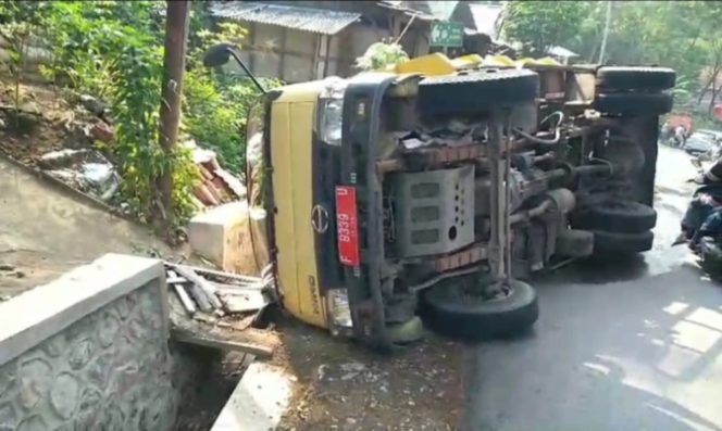 
					Akibat Pecah Ban, Truk Bermuatan Sampah Terguling di Sukabumi